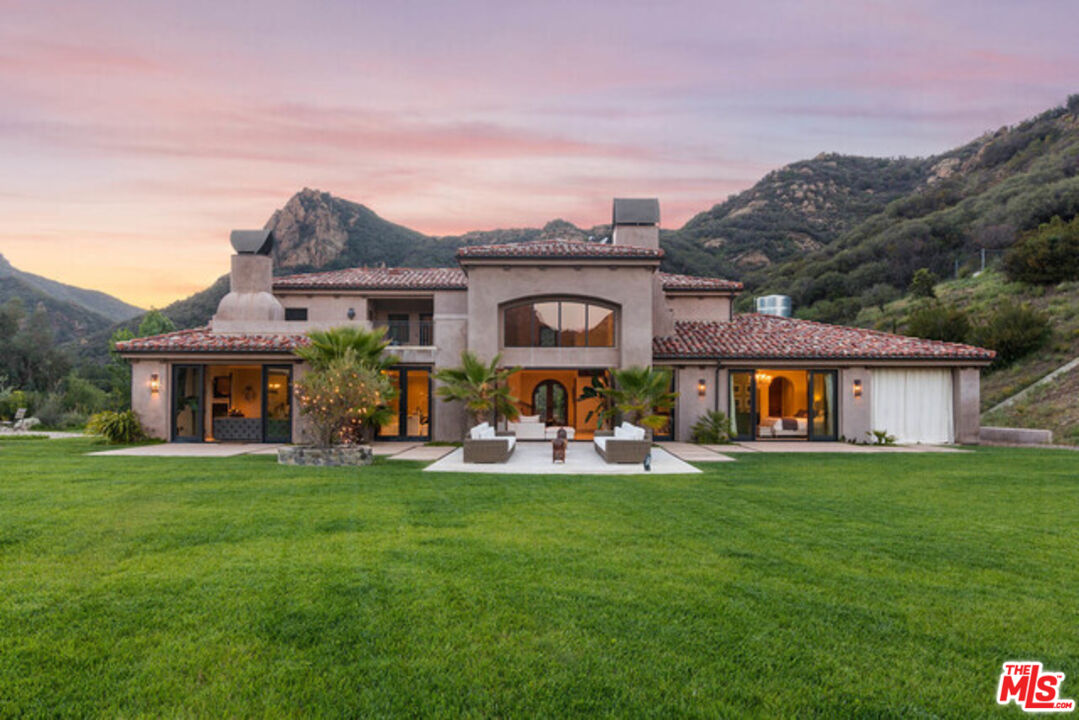 a front view of house with yard and outdoor seating