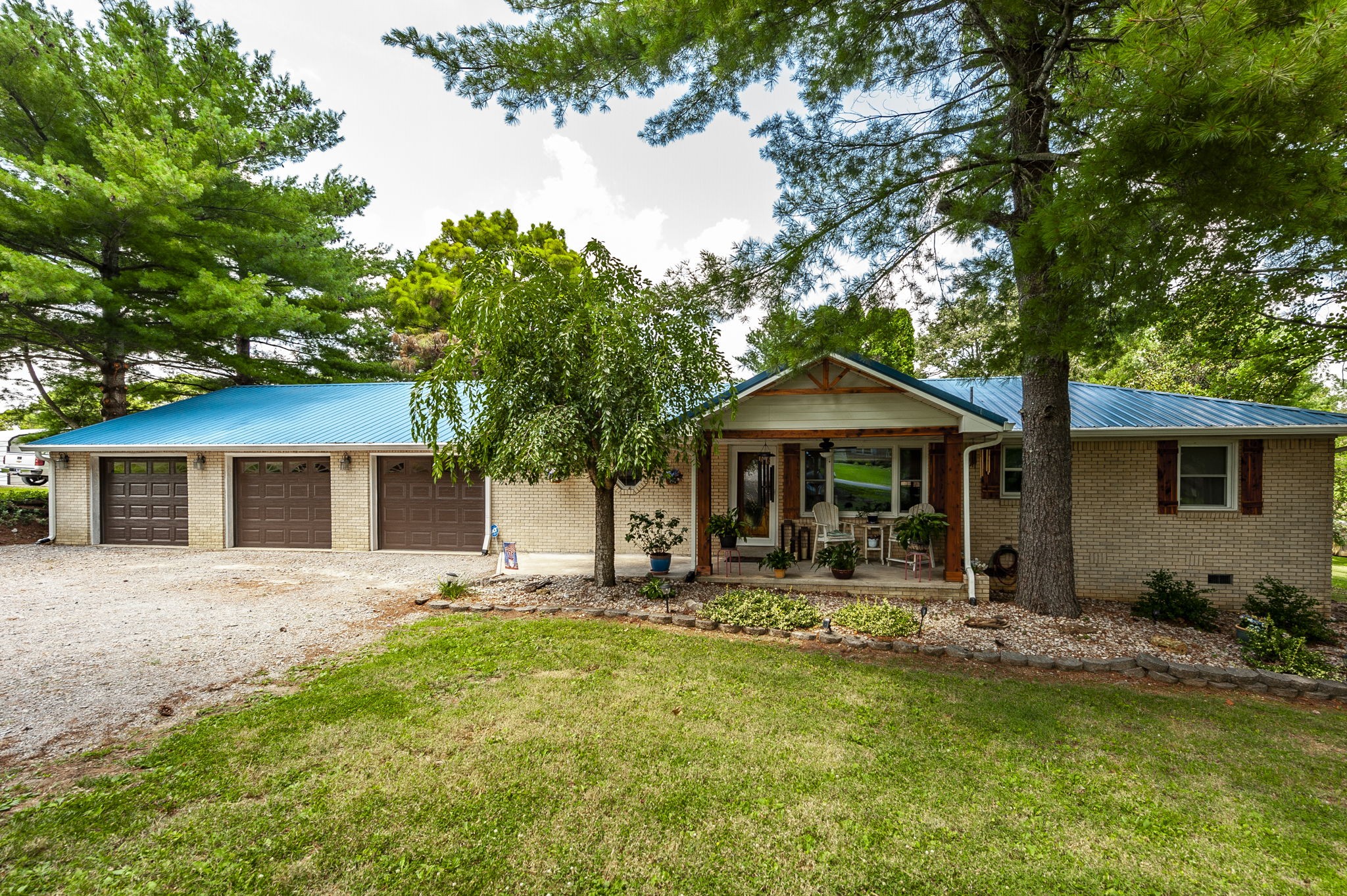 a front view of a house with yard porch and tree