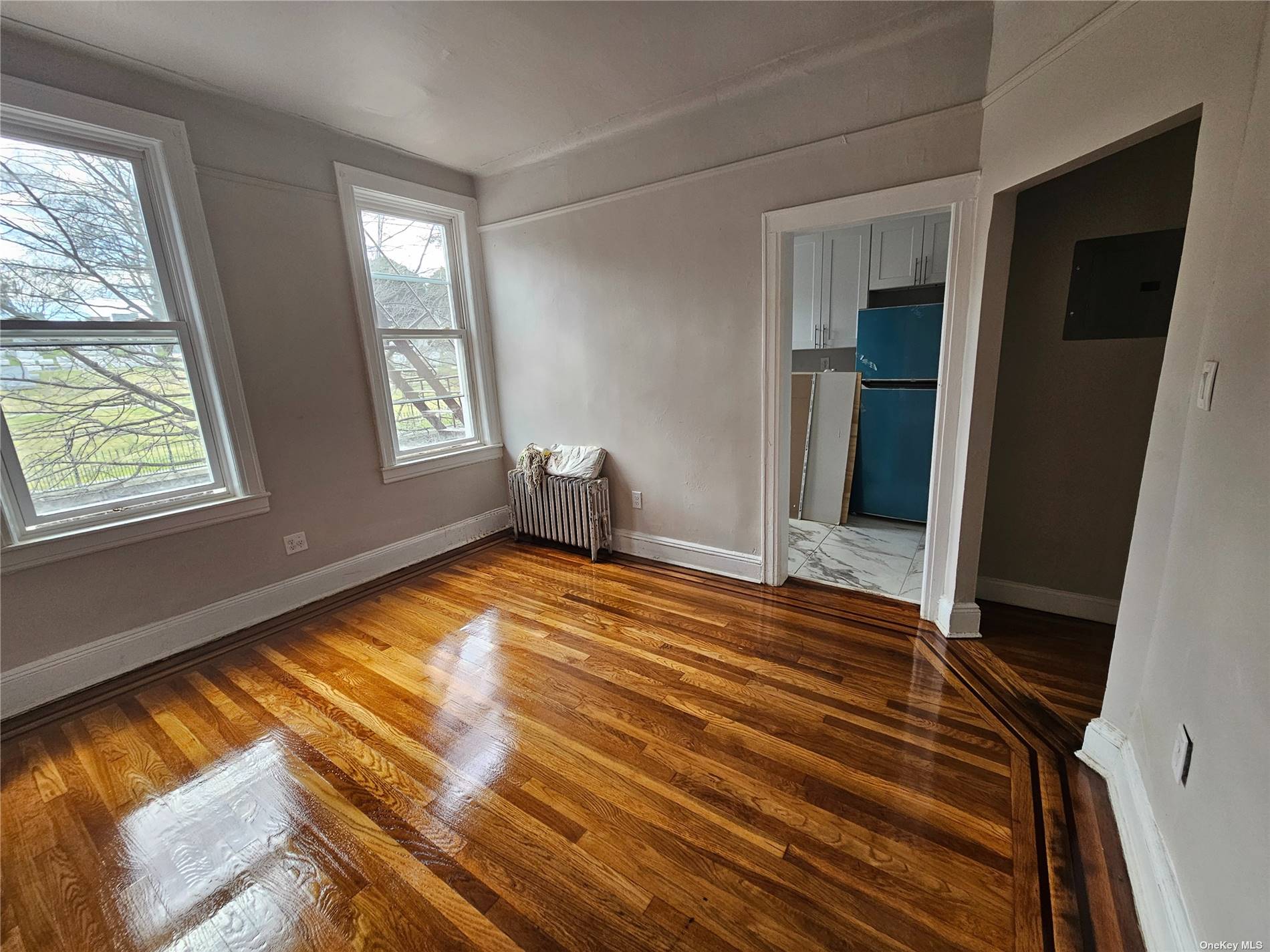 a view of empty room with window and wooden floor