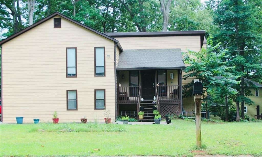 a view of a house with a yard and sitting area