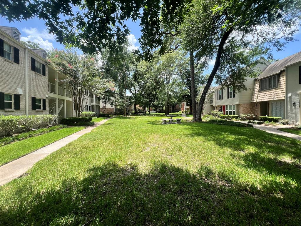 a view of a house with a big yard and large trees