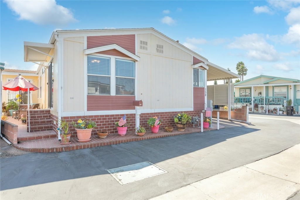 a front view of a house with a garden and mountain view