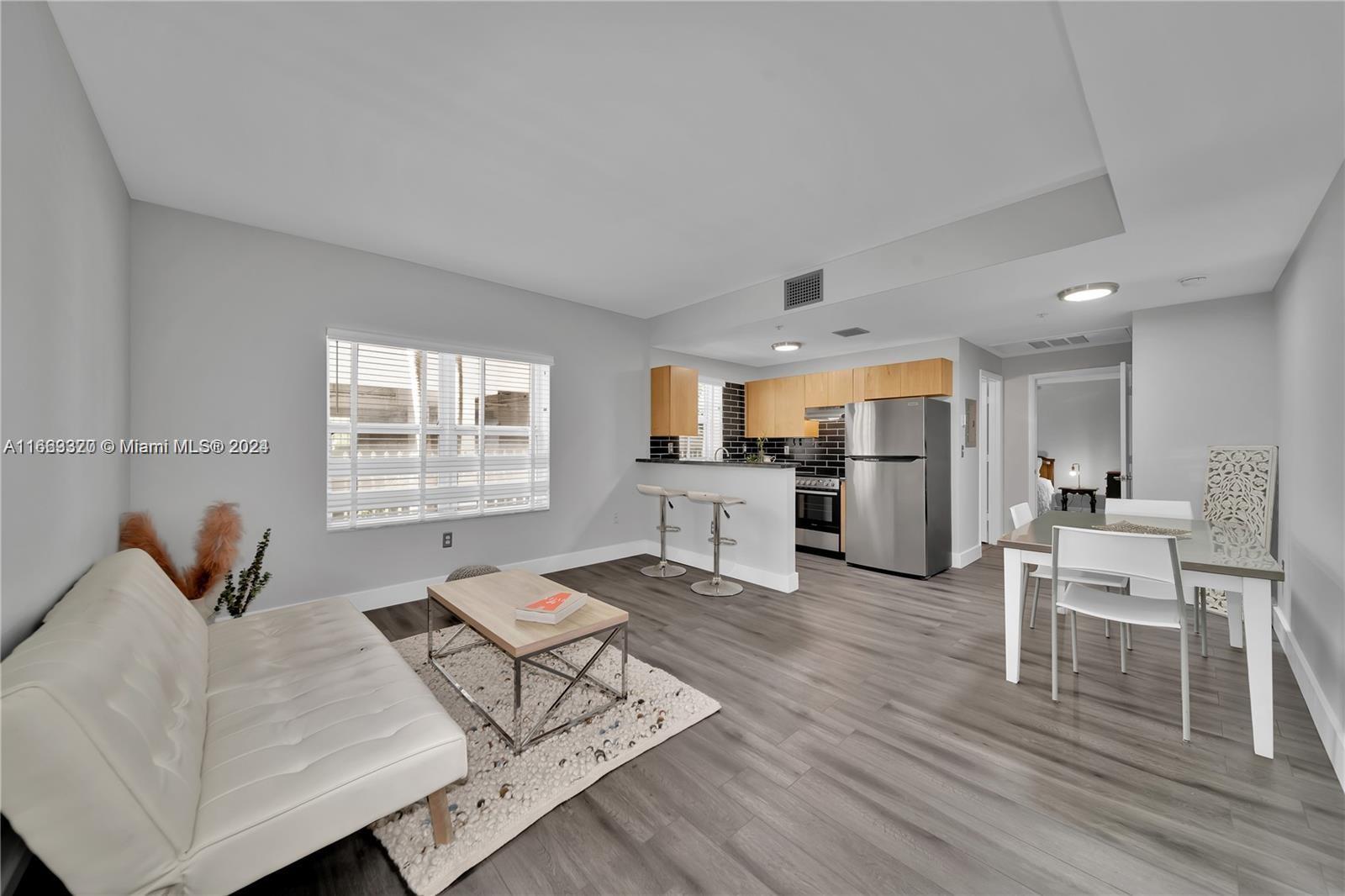 a living room with furniture and kitchen view