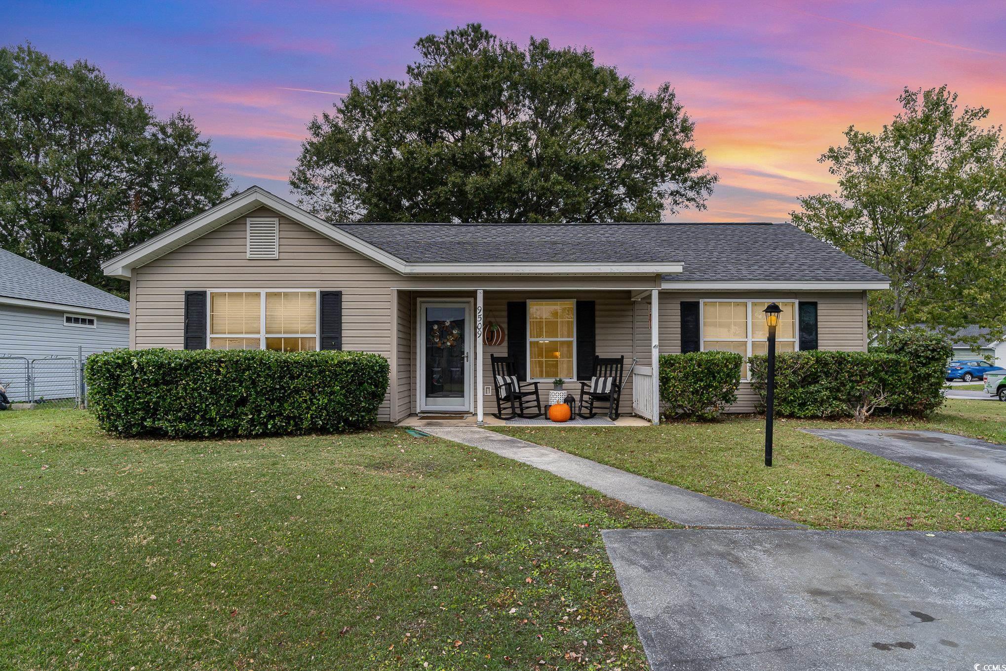 Ranch-style home featuring a lawn and a porch