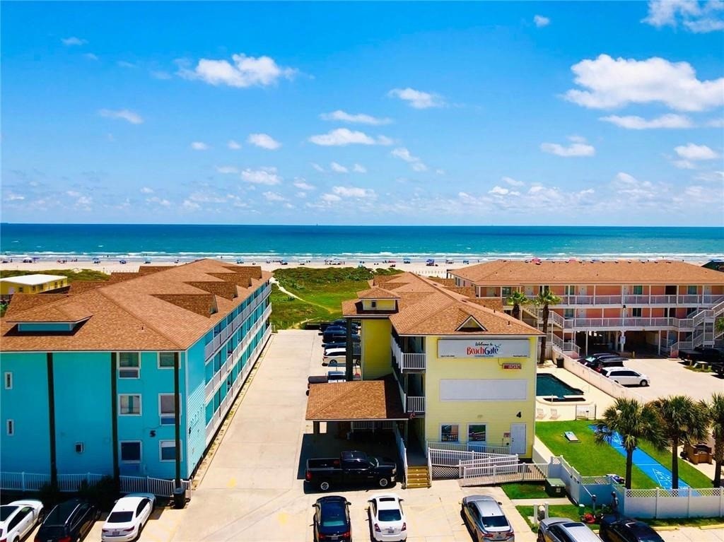 an aerial view of residential houses with outdoor space and ocean view