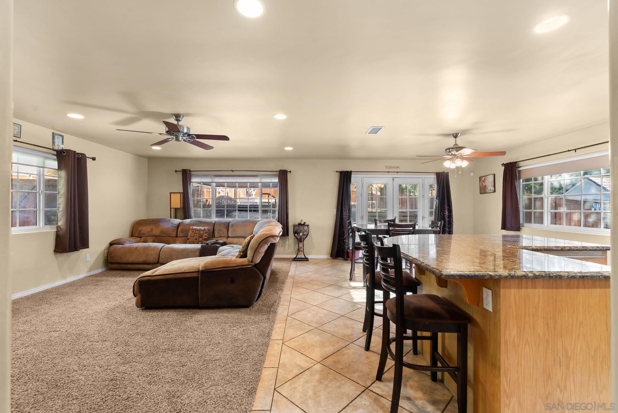 a living room with furniture and view of kitchen