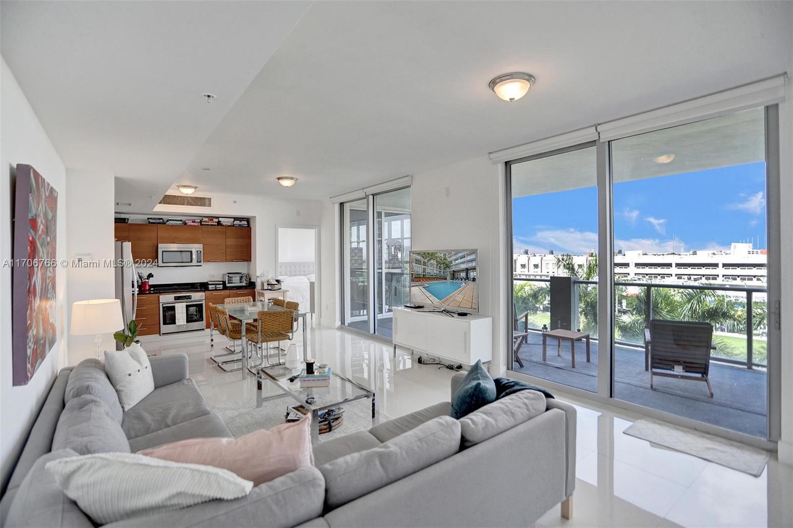 a living room with furniture a flat screen tv and a large window