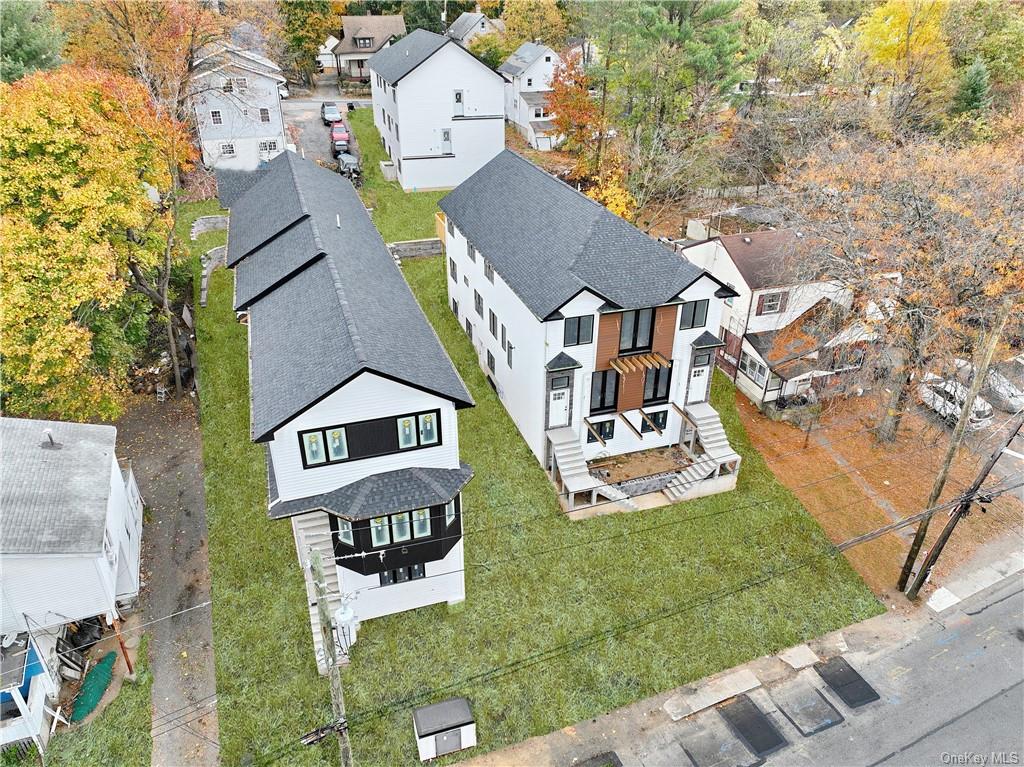 an aerial view of residential houses with outdoor space and parking