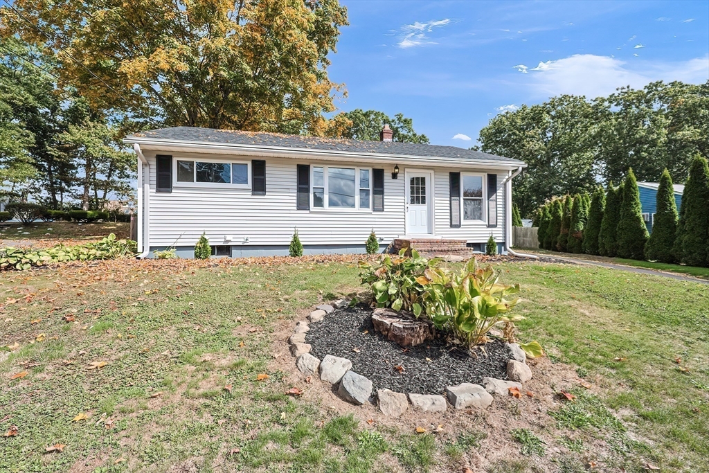 a front view of a house with a yard and potted plants