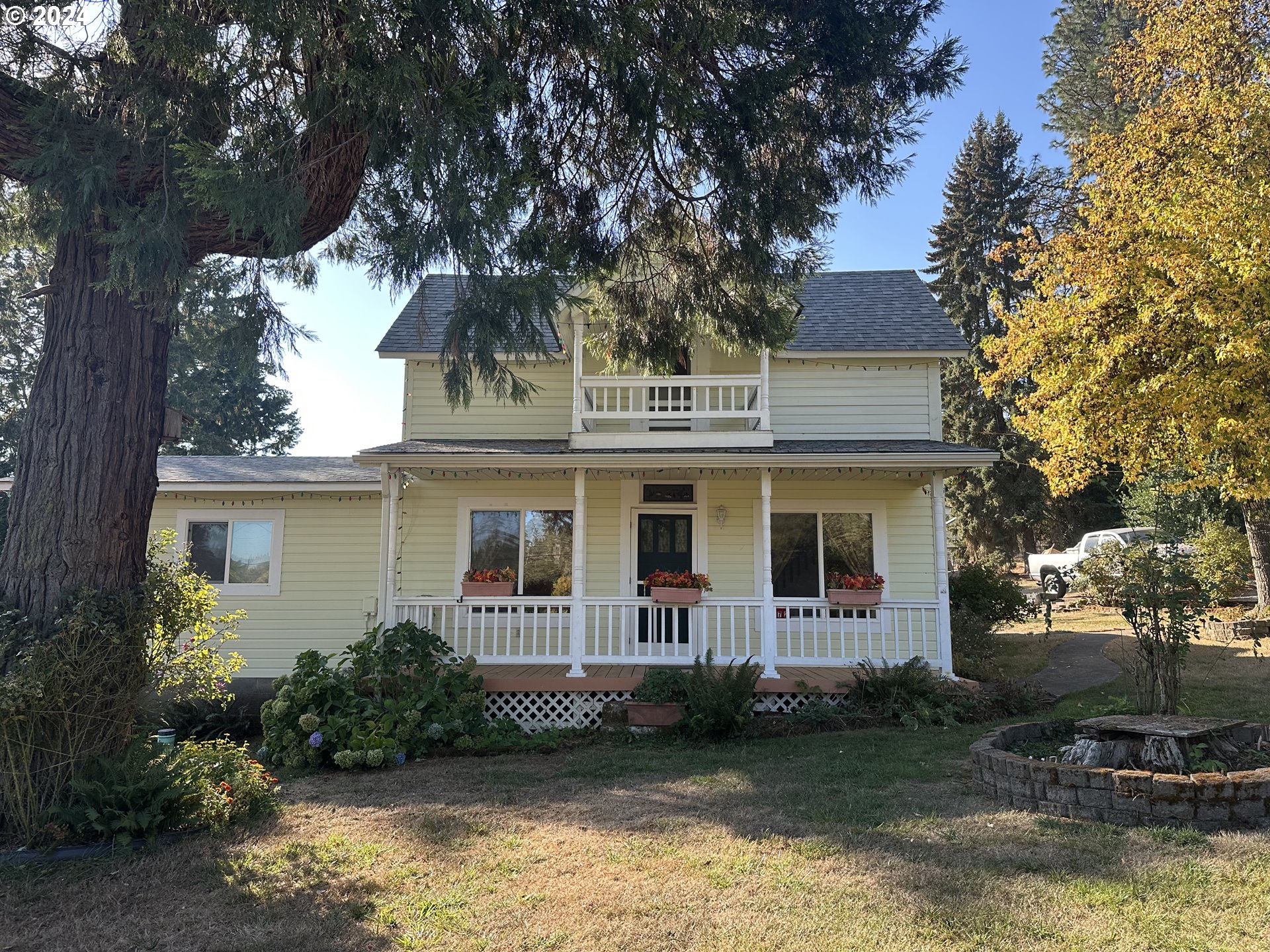 a front view of a house with a garden and trees