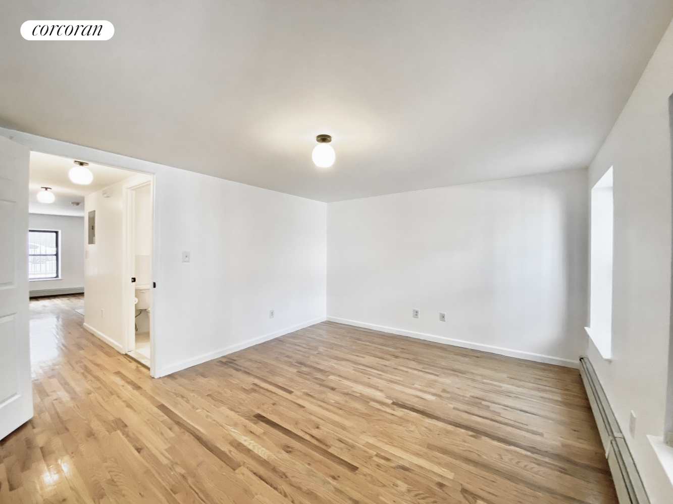 a view of empty room with wooden floor