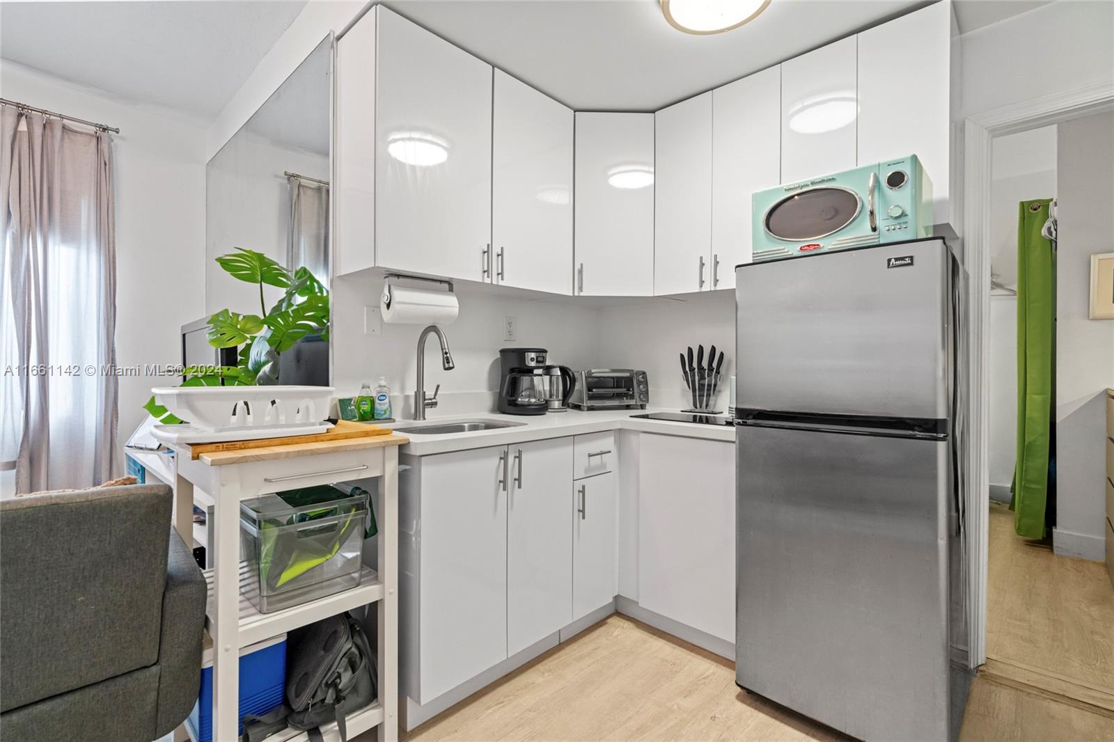 a kitchen with a refrigerator and a stove top oven