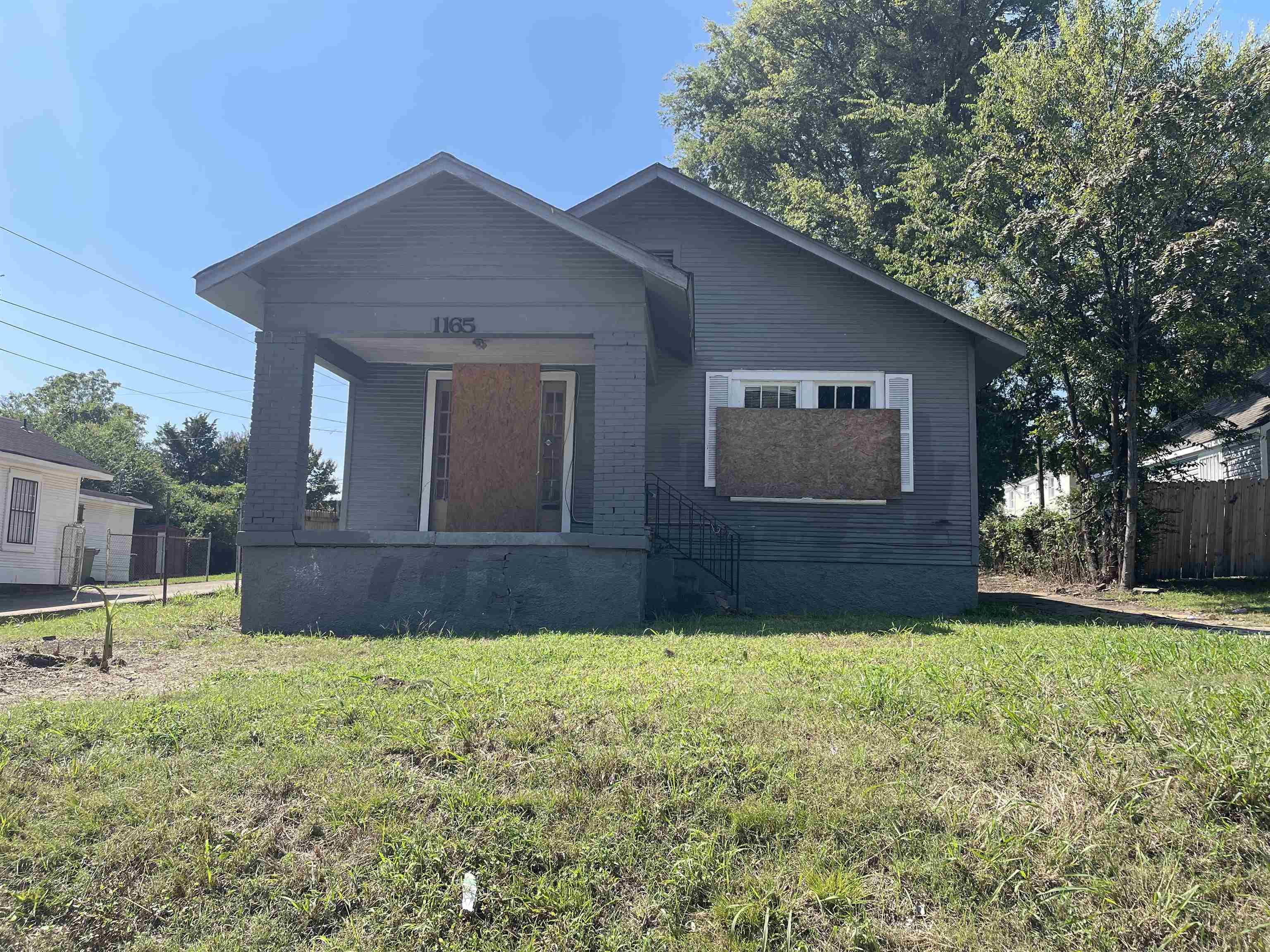 a front view of house with yard and trees in the background