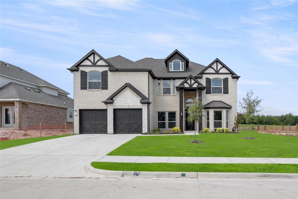 a front view of a house with a yard and garage