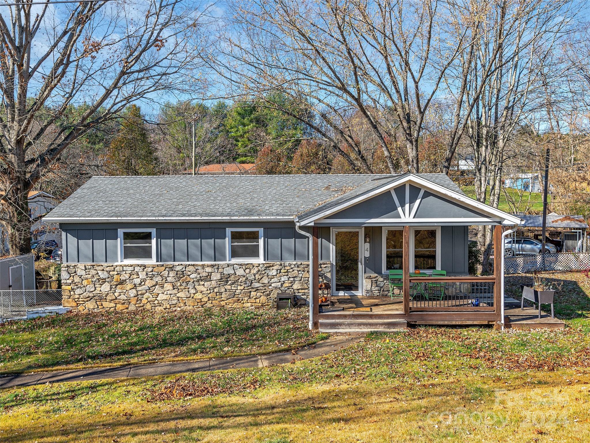 a front view of a house with a yard covered with trees