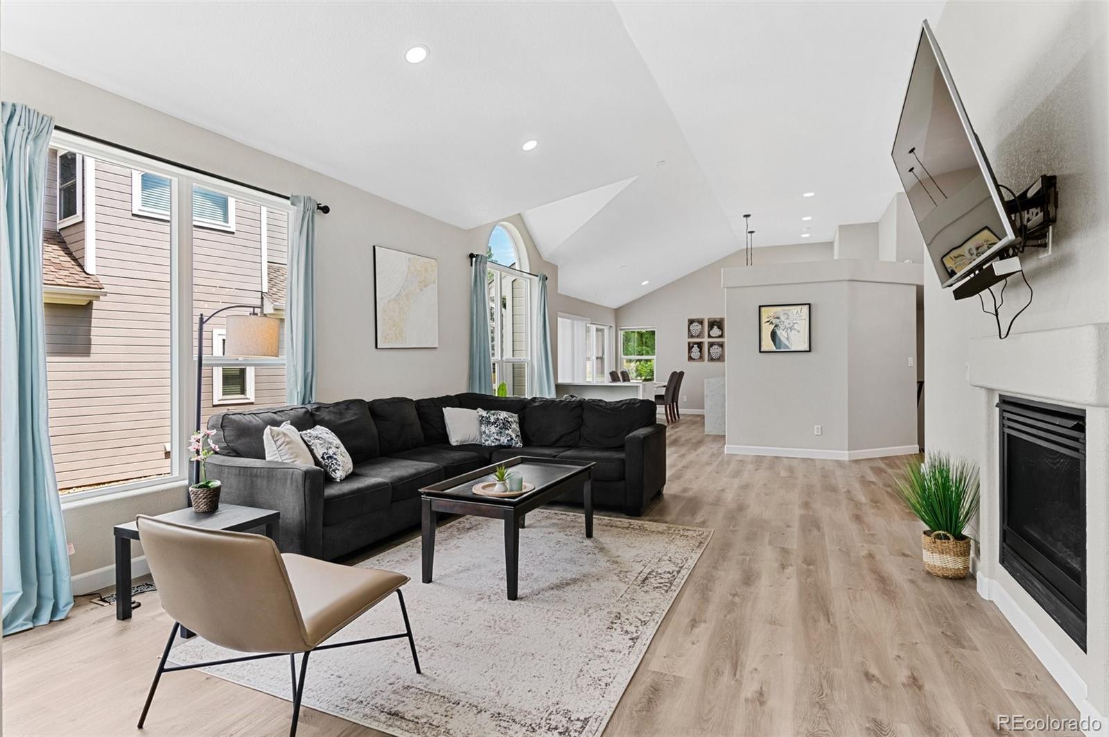 a living room with furniture a fireplace and a flat screen tv