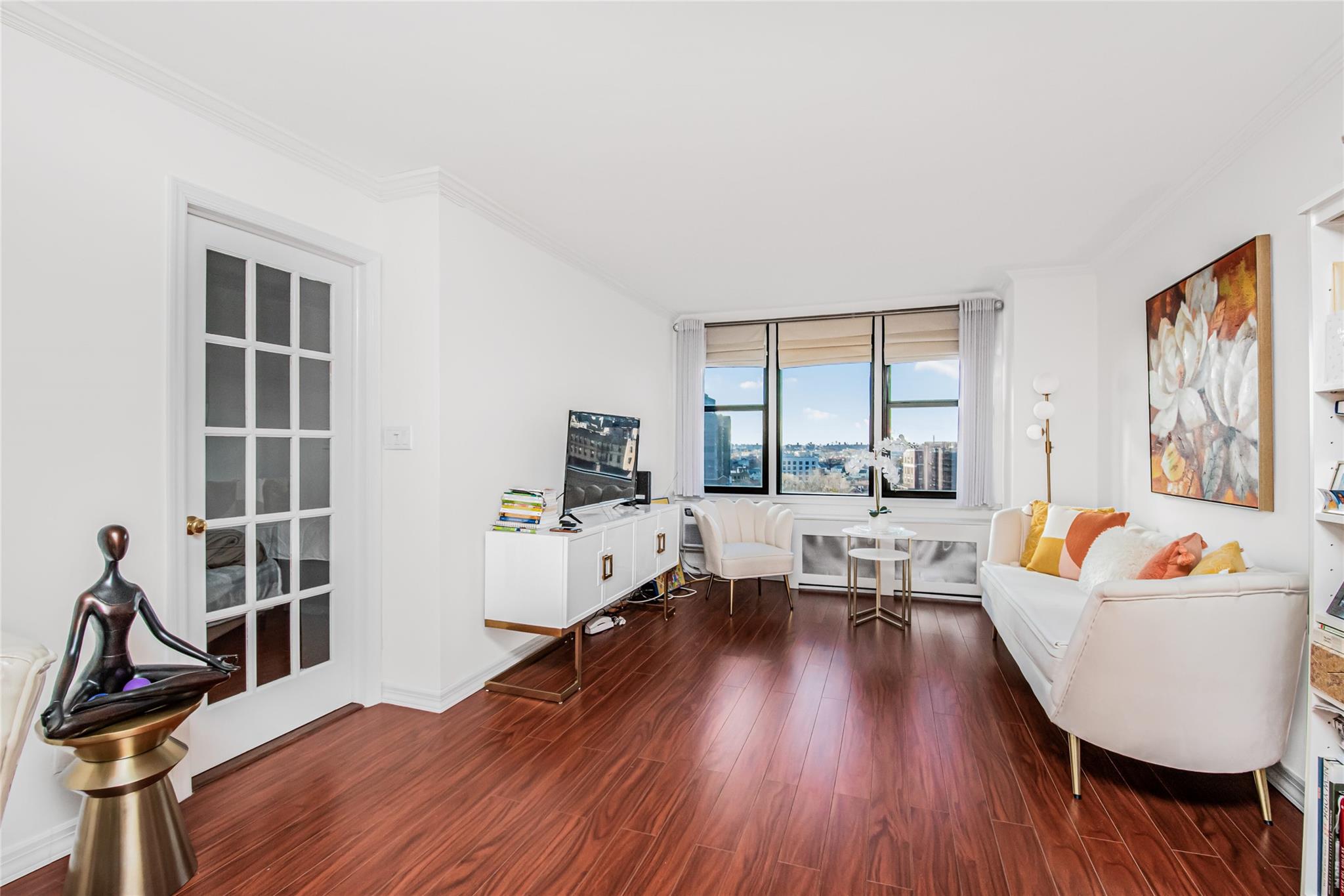 a living room with furniture and a flat screen tv with wooden floor