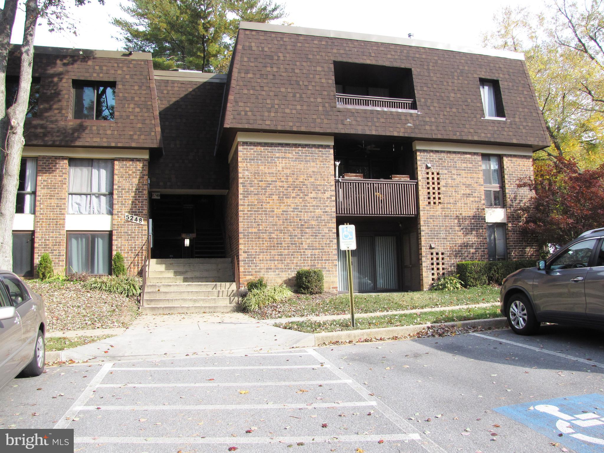 a view of a brick house with many windows next to a road