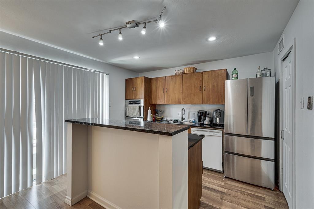 a kitchen with granite countertop stainless steel appliances a refrigerator and a sink