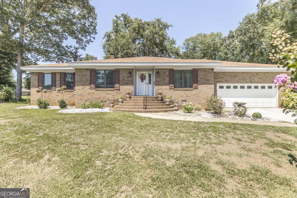 a front view of house with yard seating and green space