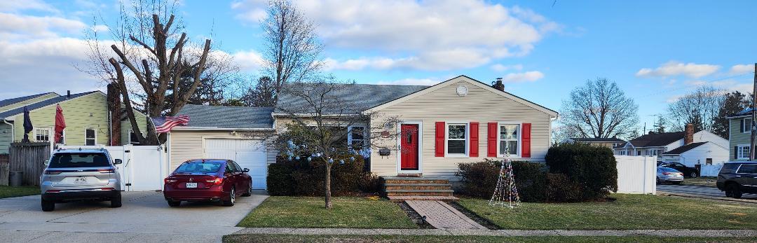 View of front of property with a garage and a front lawn