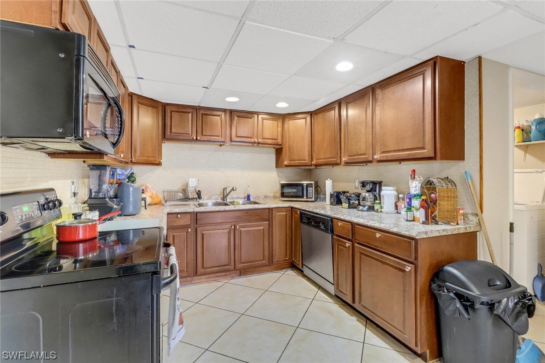 a kitchen with a sink dishwasher stove and cabinets