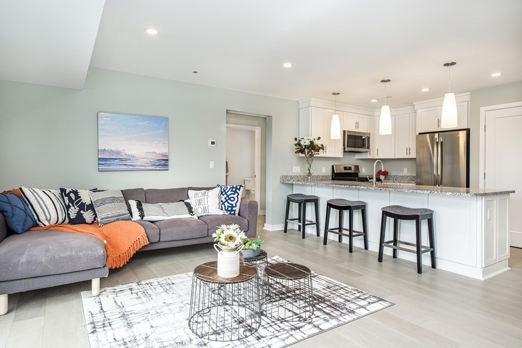 a living room with furniture and kitchen view