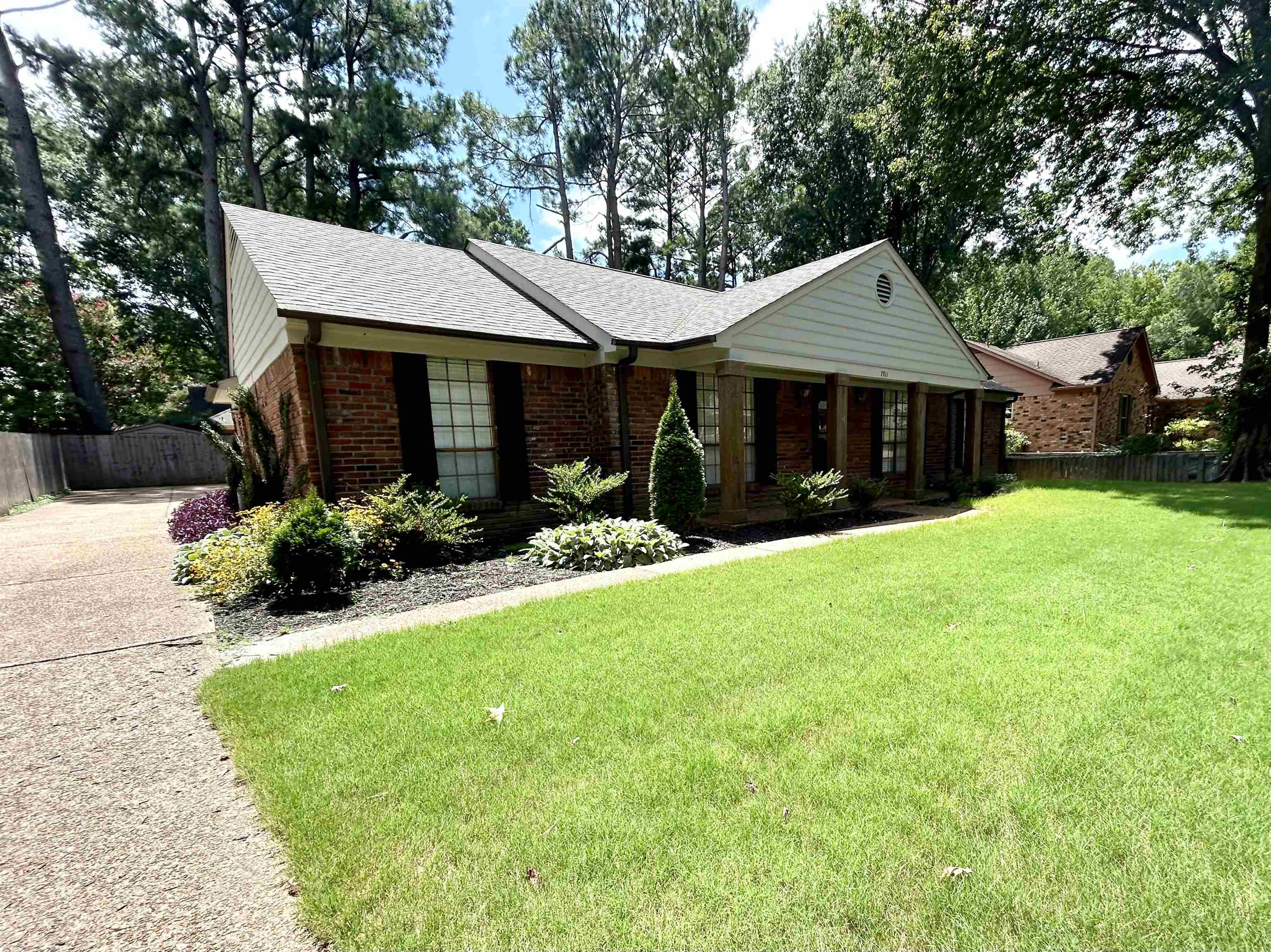 a front view of a house with yard and green space