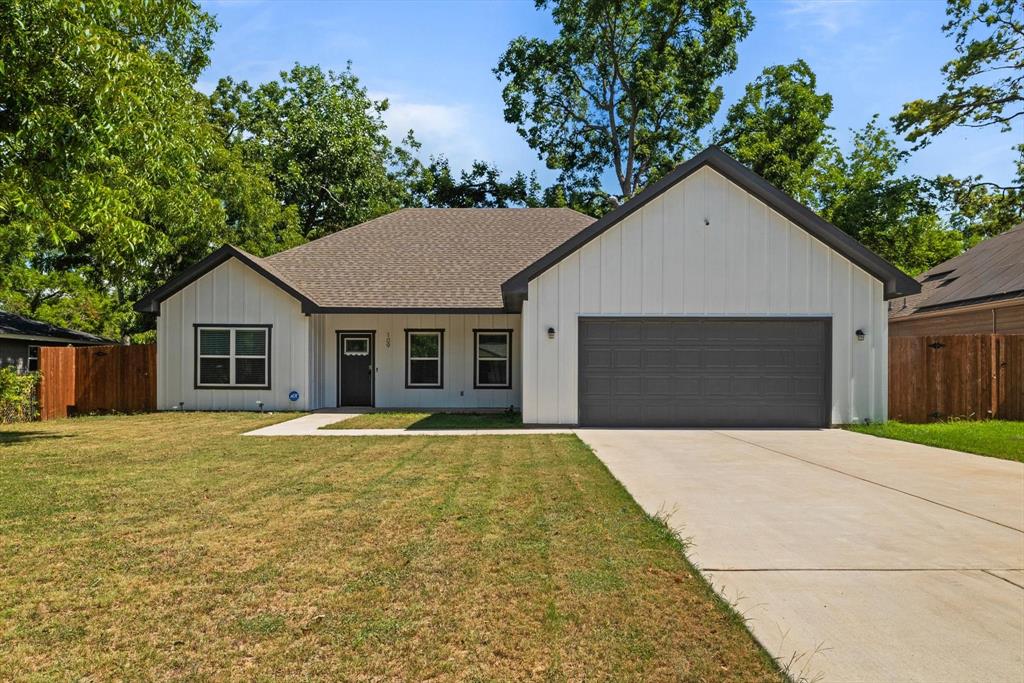 a front view of a house with yard and trees