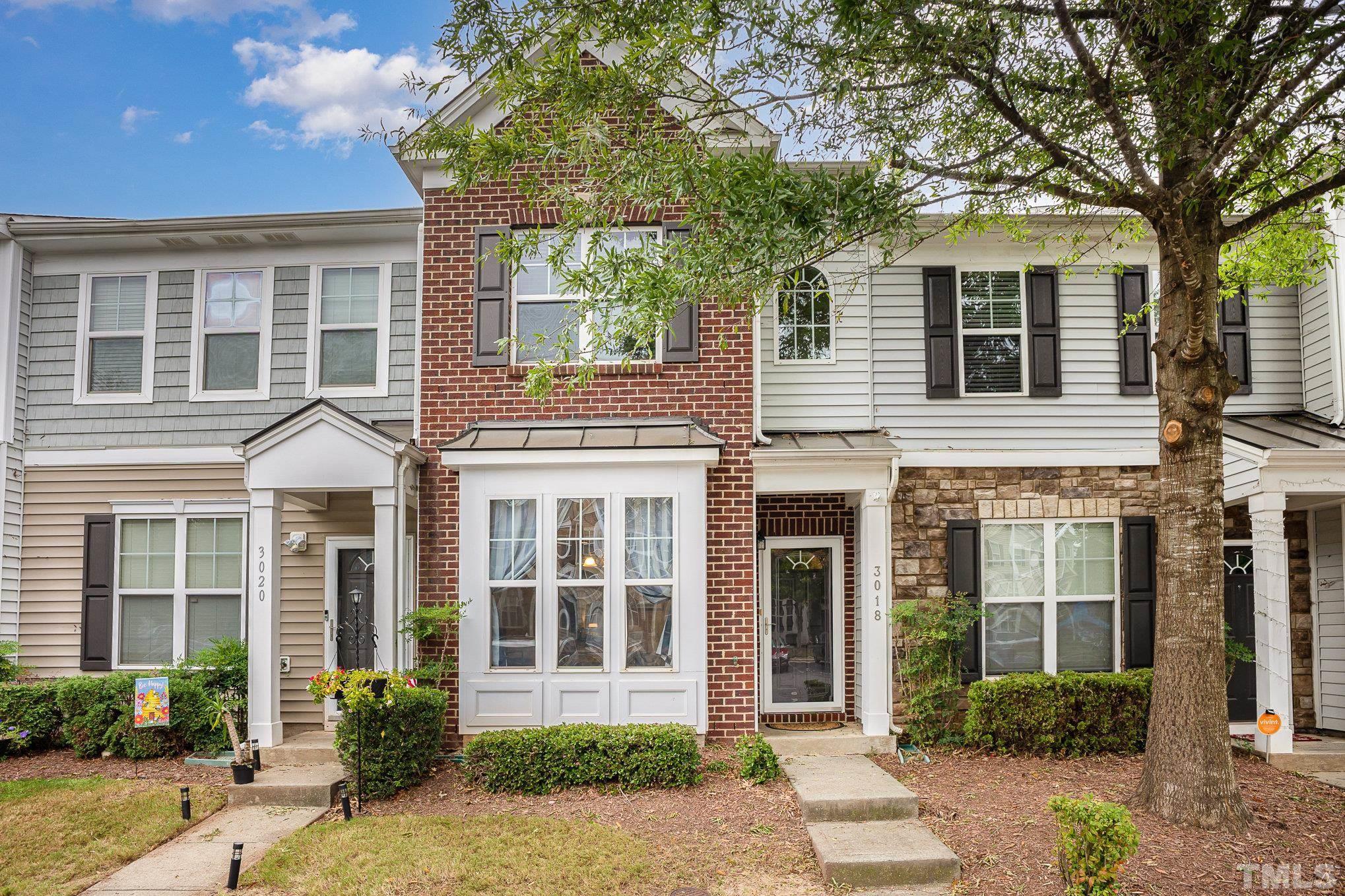 front view of a brick house with a yard