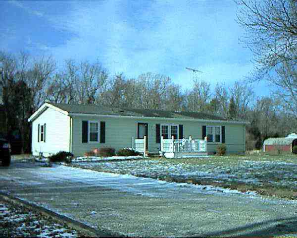 a front view of house with yard and trees around