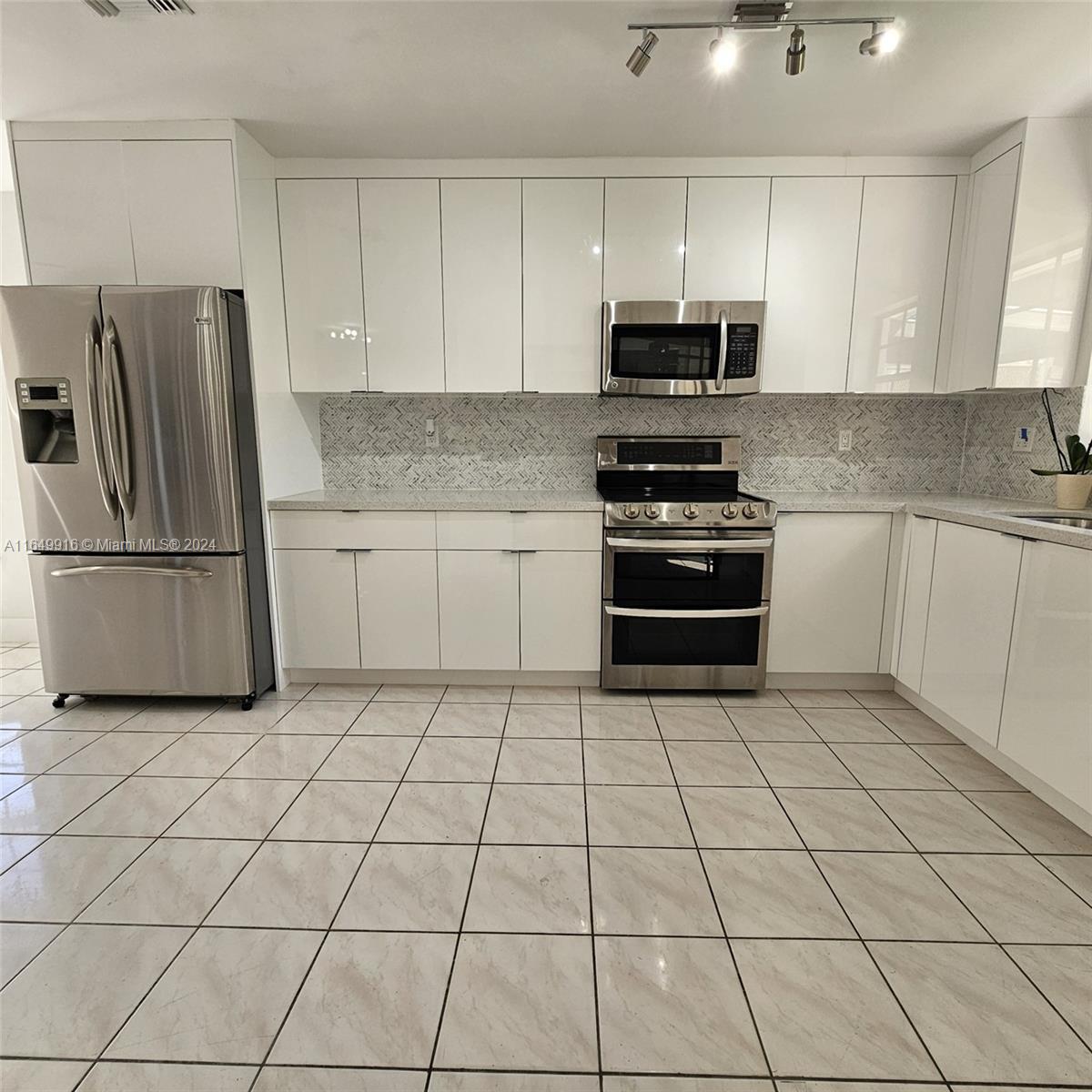 a kitchen with stainless steel appliances granite countertop a refrigerator and a stove top oven