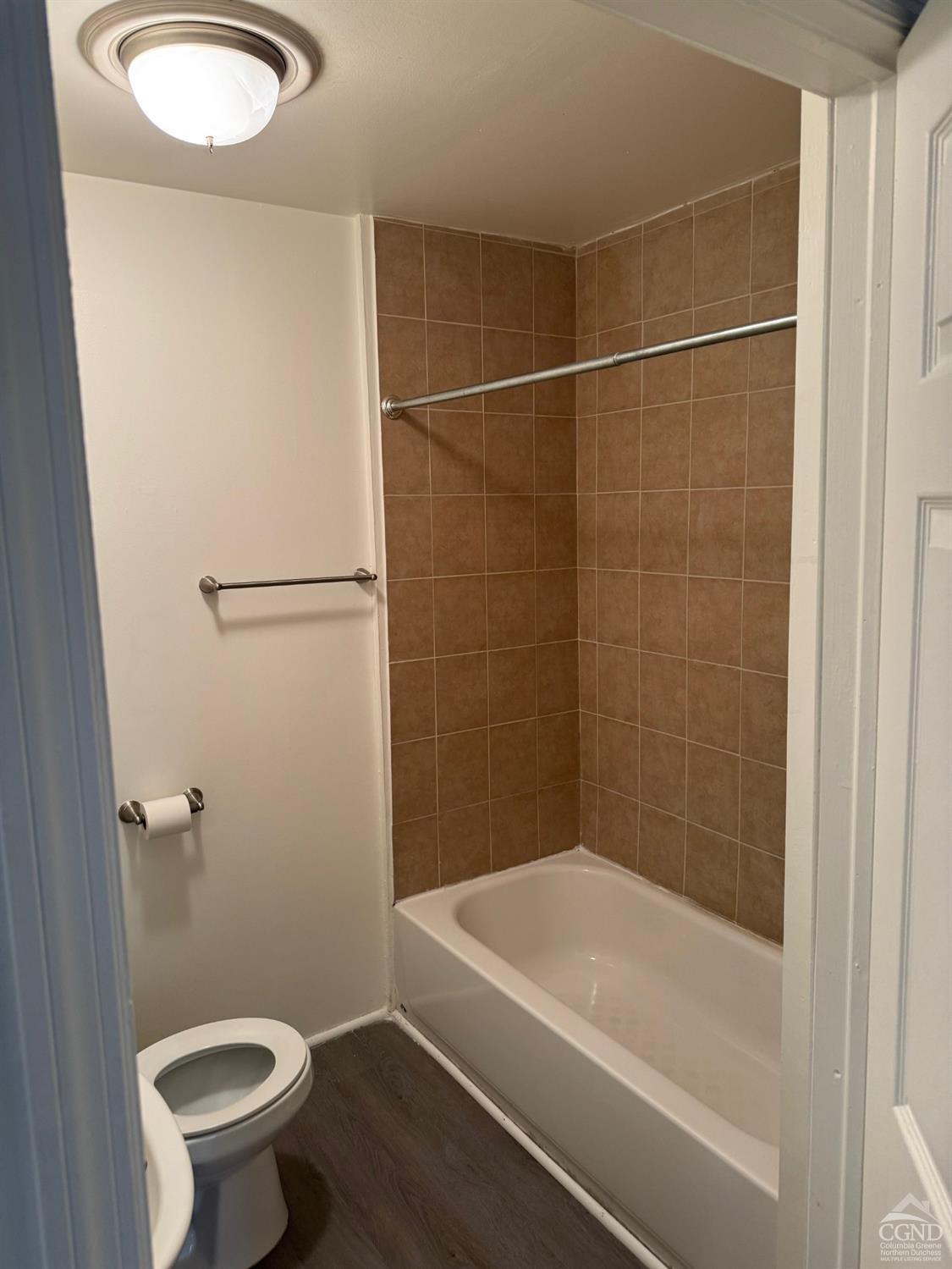 a bathroom with a granite countertop sink a toilet and a bathtub