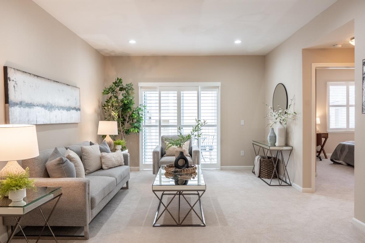 a living room with furniture white walls and a large window