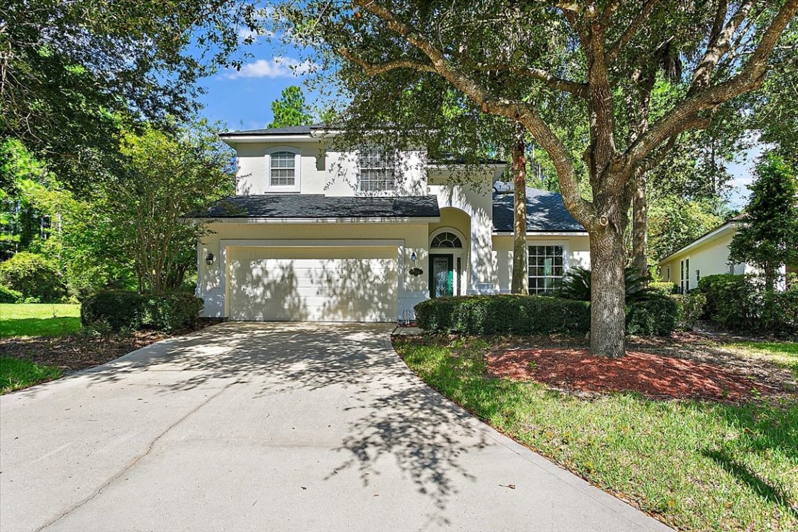 a front view of a house with a garden and yard