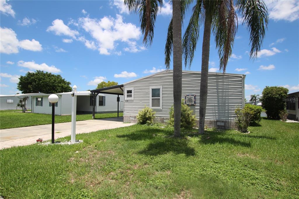 a view of a house with backyard and a tree