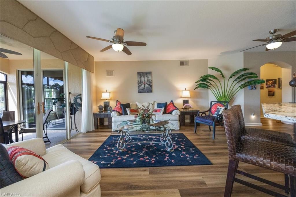 Living room with ceiling fan and hardwood / wood-style flooring