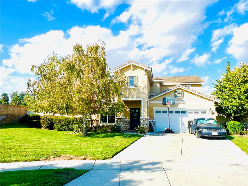 a view of a house with a big yard plants and large trees