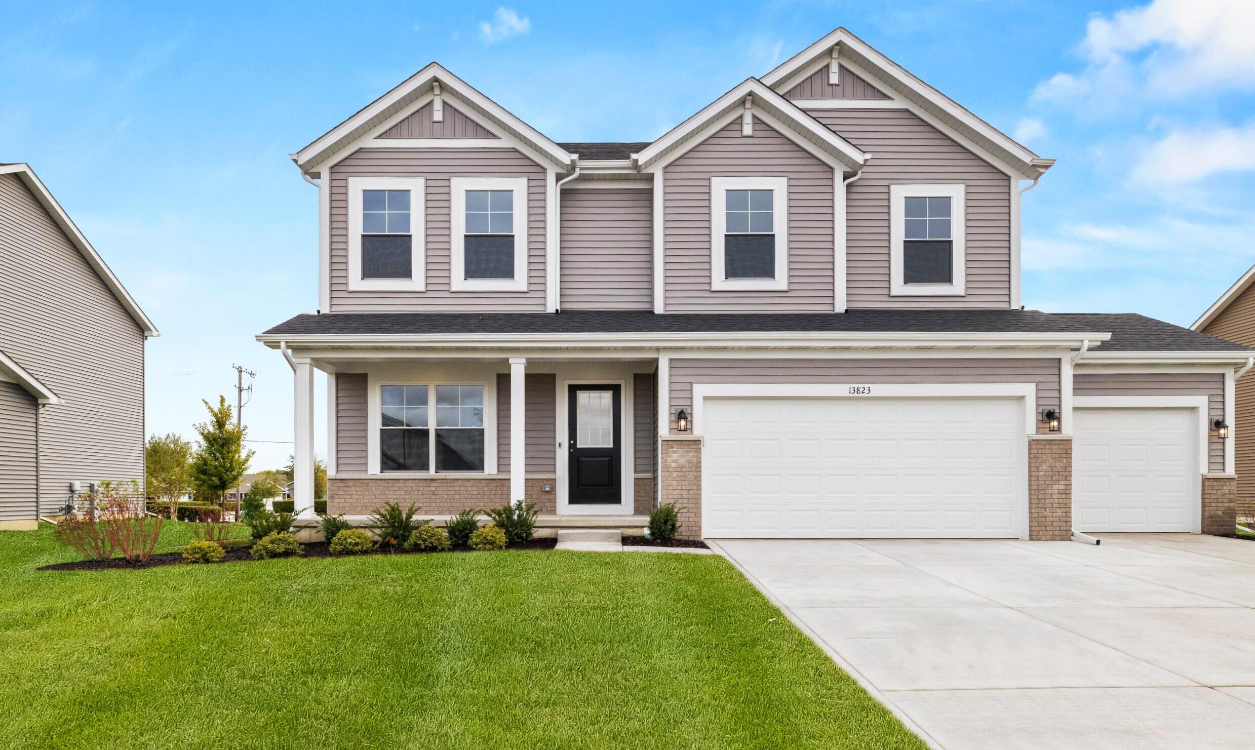 a front view of a house with a yard and garage