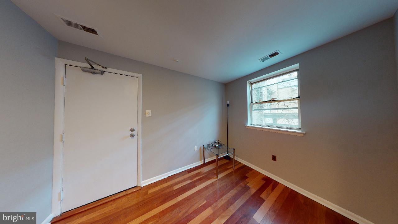 a view of a room with wooden floor and window