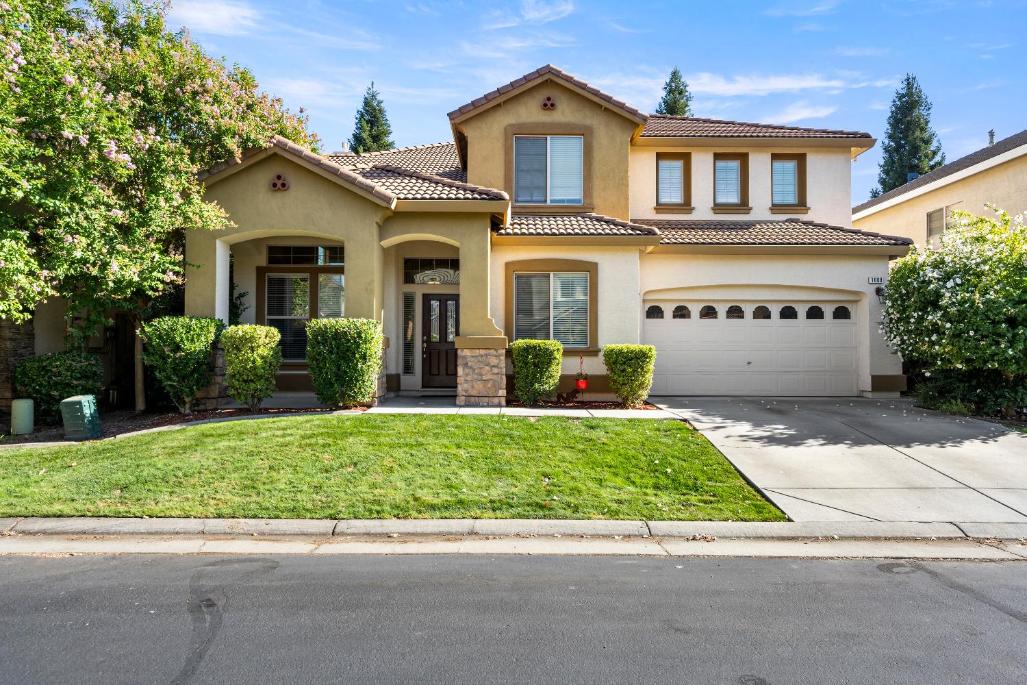 a front view of a house with a yard and a garage