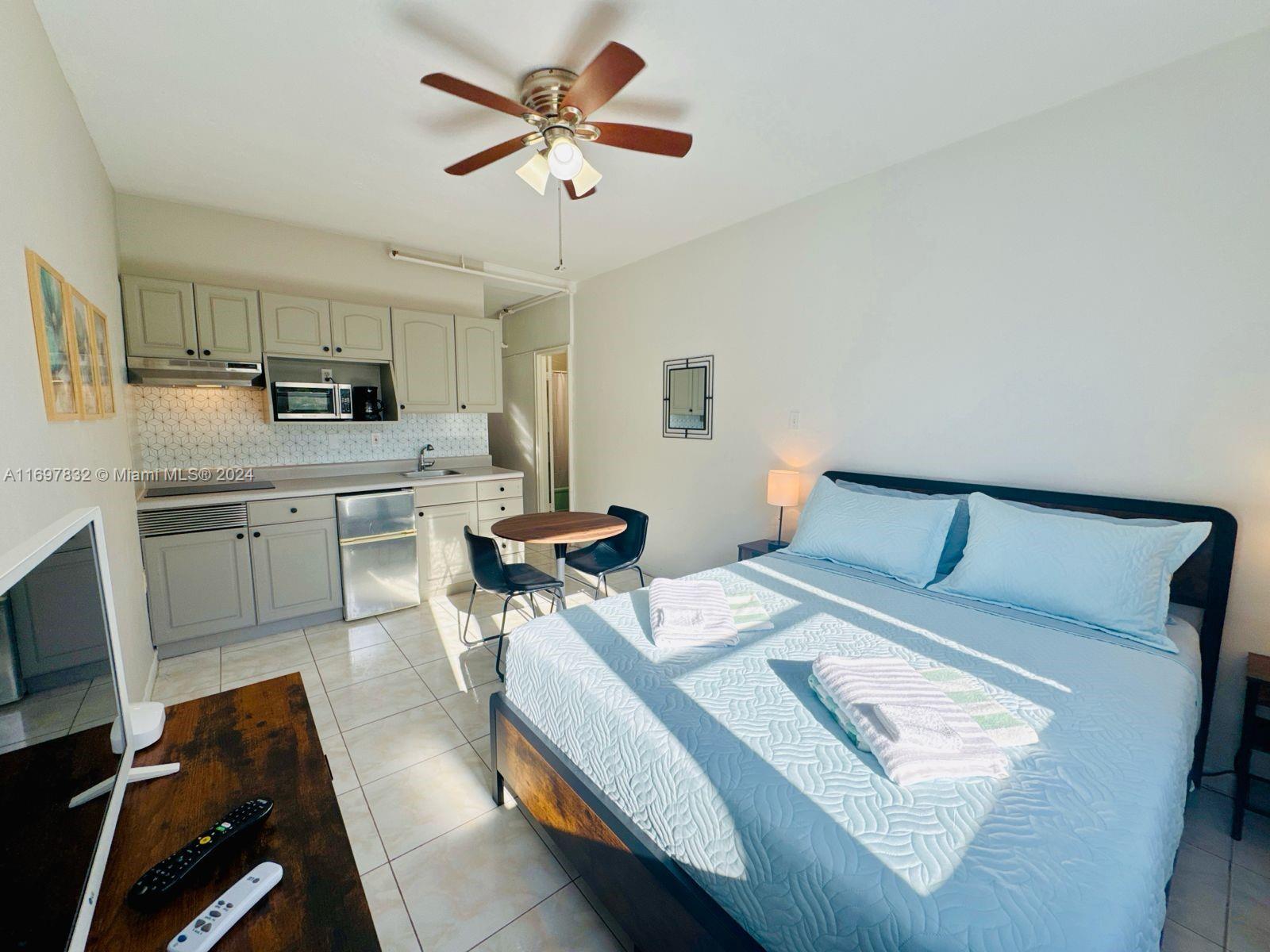 a bedroom with a bed a chair and a chandelier