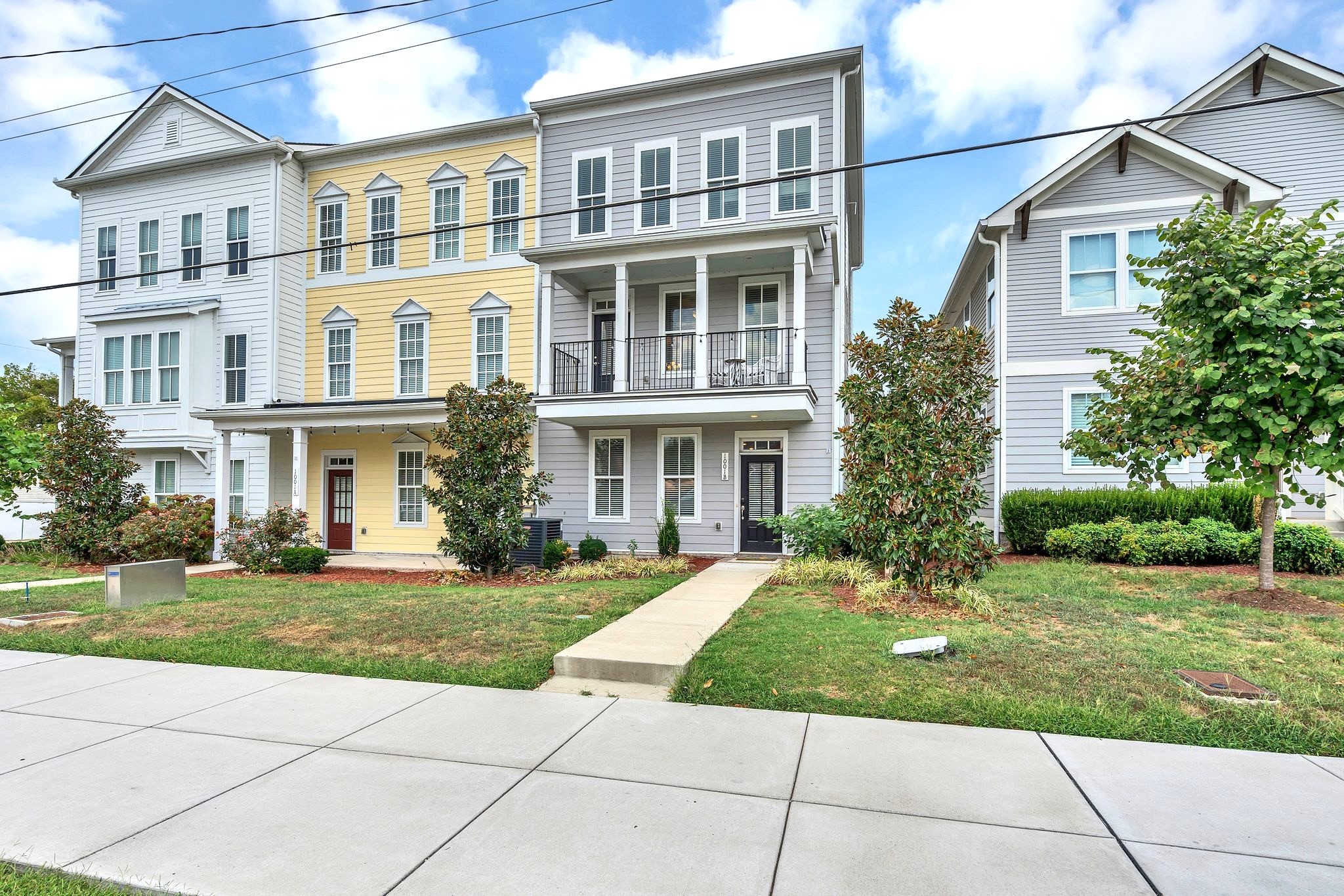 a front view of a residential apartment building with a yard