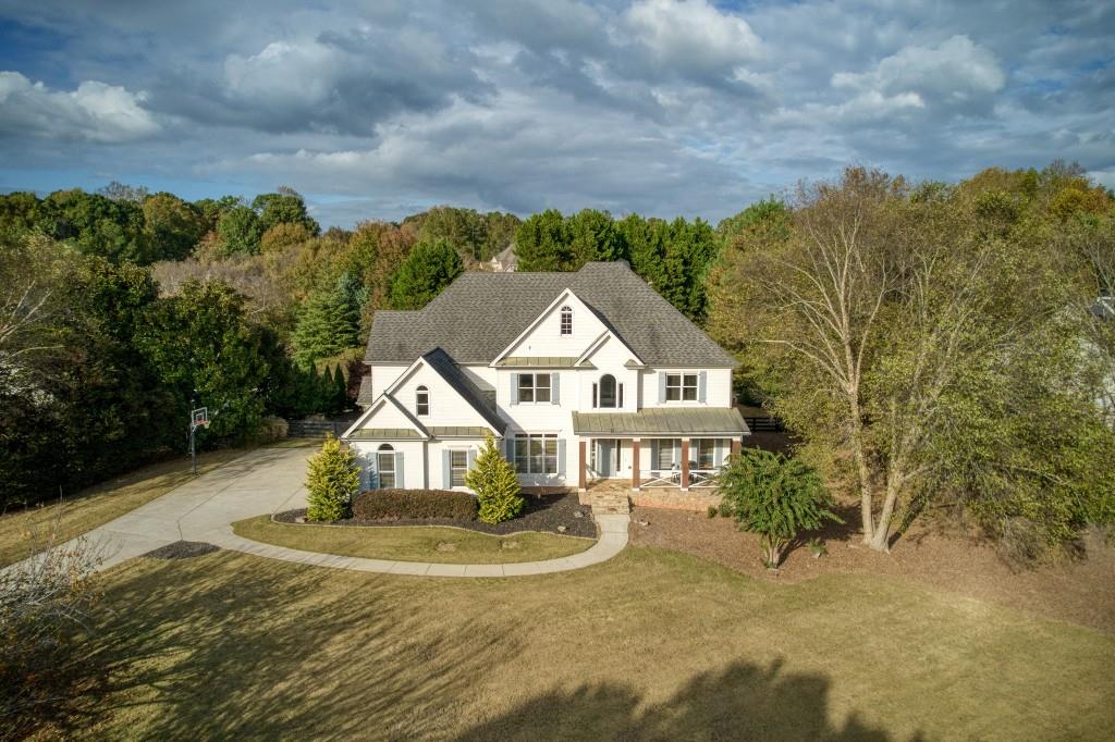 a view of a house with a yard and large trees