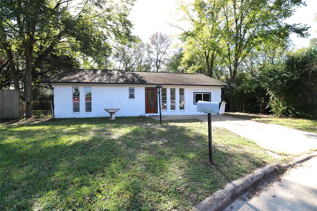 a view of a house with a yard patio and a tree