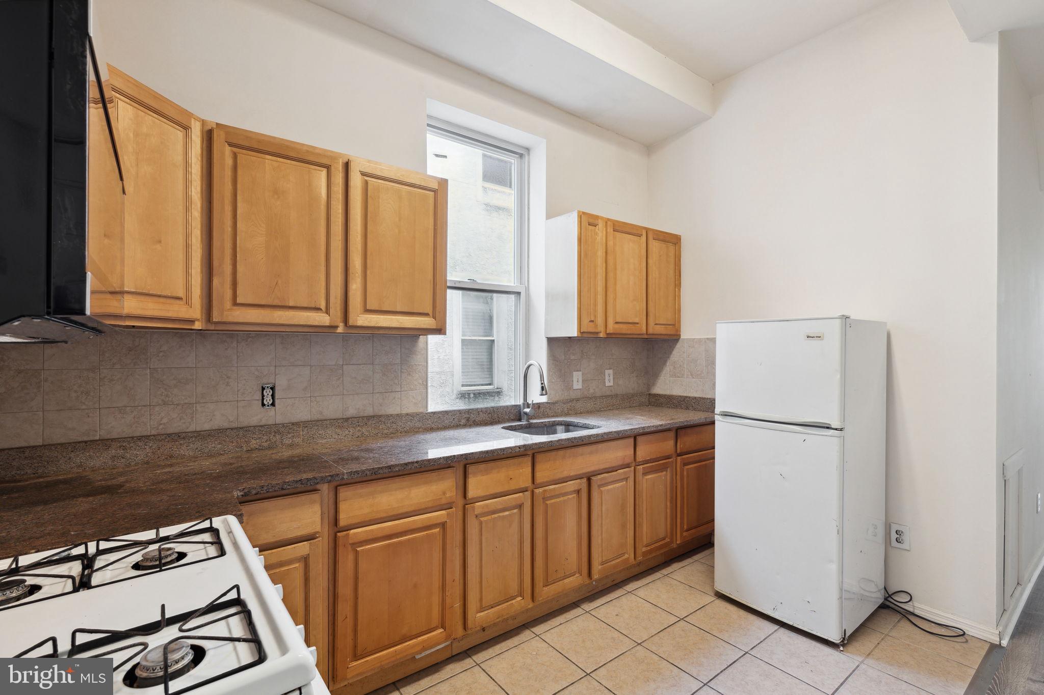 a kitchen with a sink a stove and white cabinets