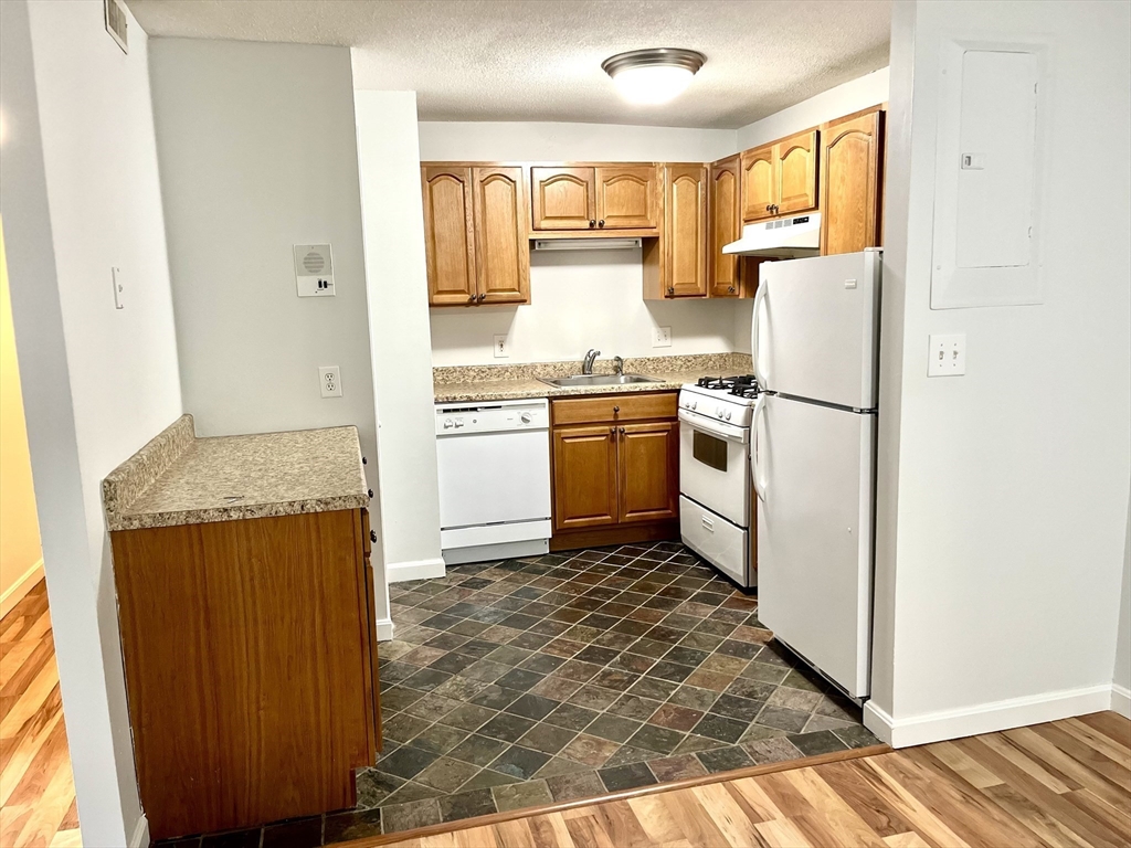 a kitchen with stainless steel appliances granite countertop a refrigerator and a stove