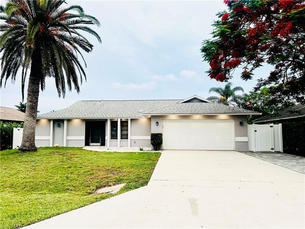 a front view of house with yard and trees around