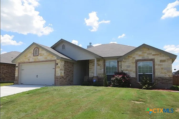 a front view of a house with a yard and garage