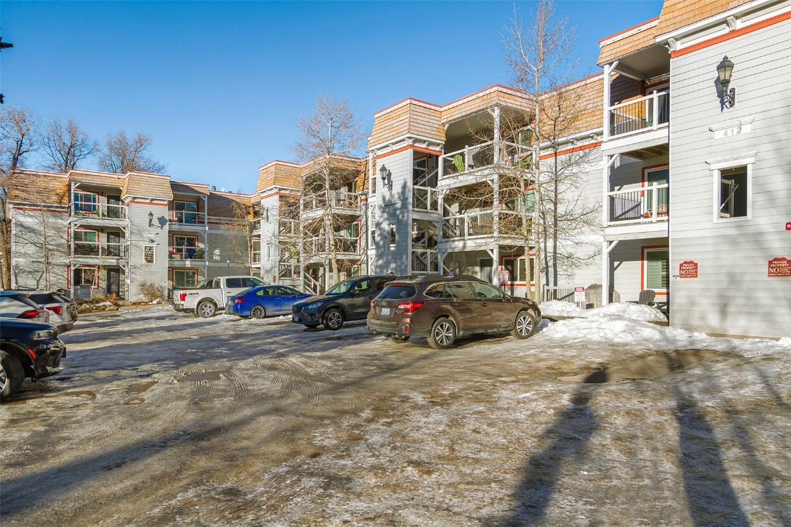 a view of building with cars parked in front of it